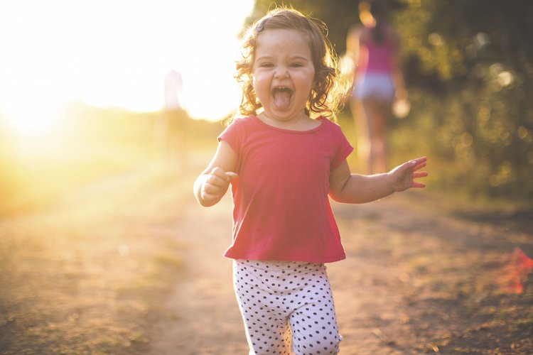 Happy girl running on a dusty road