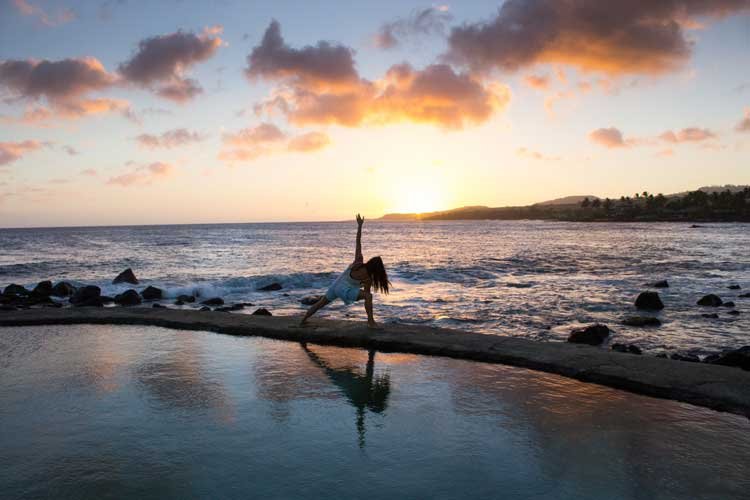 woman doing yoga at the beach