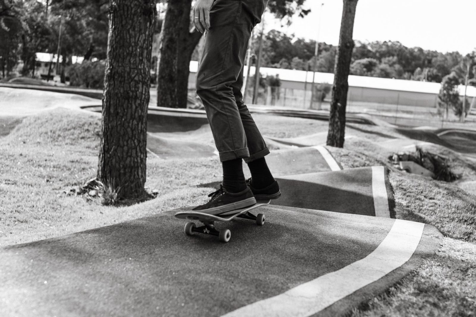 crop skater riding skateboard on asphalt ramp in park