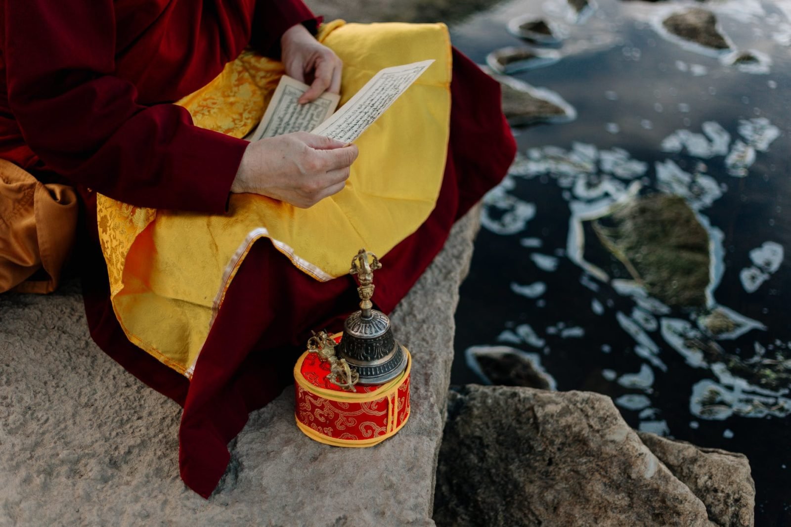 person in red and yellow long sleeve shirt holding white paper